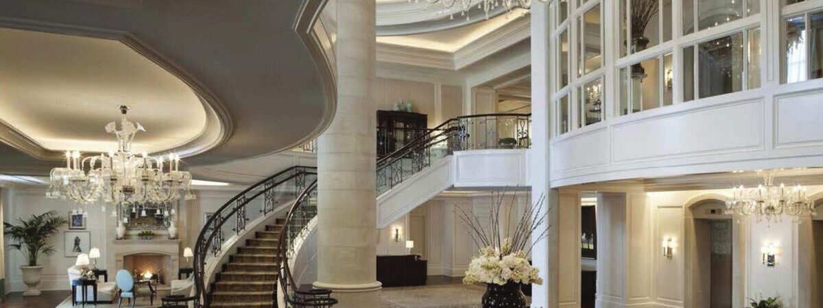The stair hall of a hotel lobby, galleried over two floors.